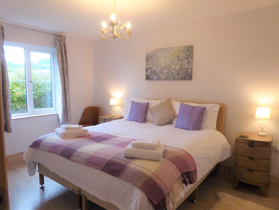 Bedroom 4 (ground floor) with superking size bed or 2x single beds, smart TV, with views over pasture land and hills.