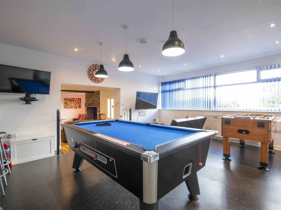 Welsh Row House games room. Seats in front of Xbox with Xbox games Pass.  Football Table and Pool Table. Second TV near pool table. Games room leading