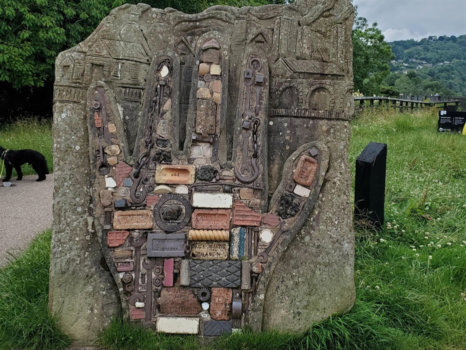 The hand sculpture embedded in to rock made from bricks and other objects