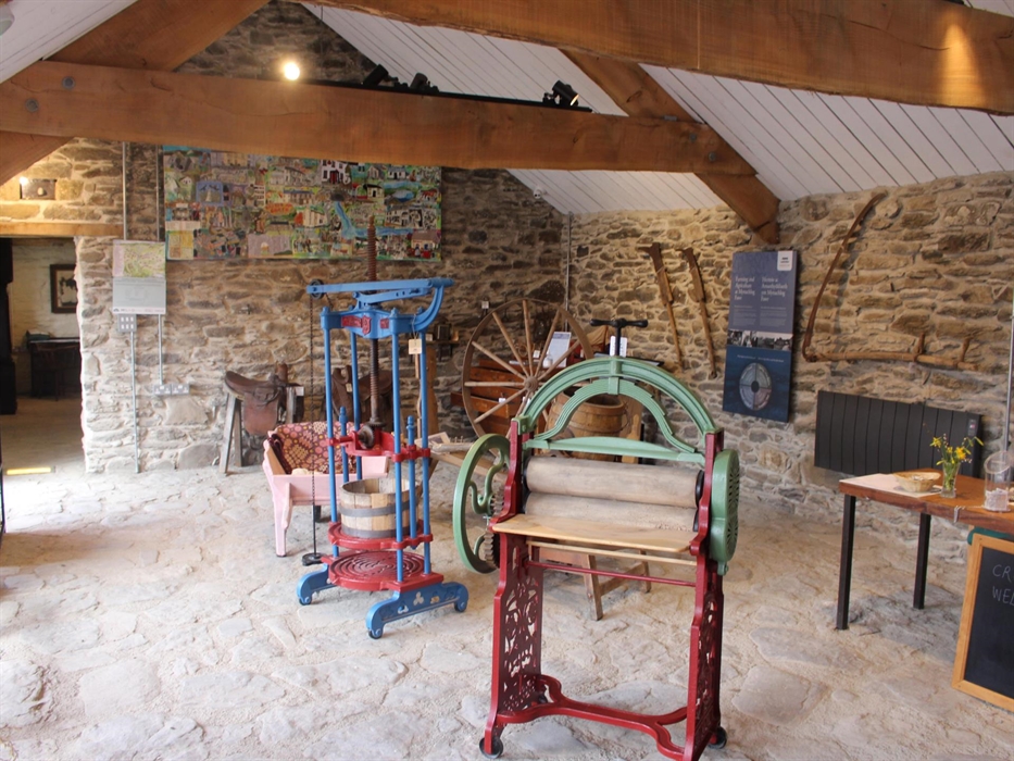 Interior of the exhibition space, showing mangle, cheese press and other objects