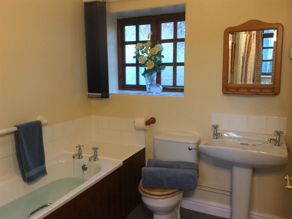 Aberyscir Coach House bathroom with bath and electric over bath shower