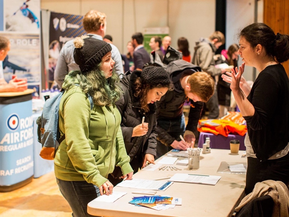 Delegates getting information from an information stand at an exhibition.