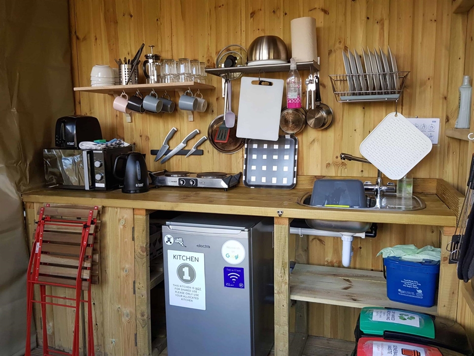 a wooden camping kitchen with fridge microwave hob kettle toaster equipment crockery