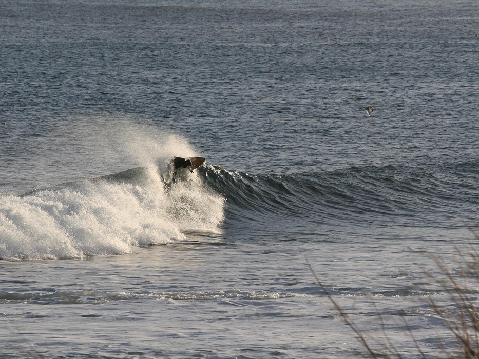 A surfer top turns on wave beaking left
