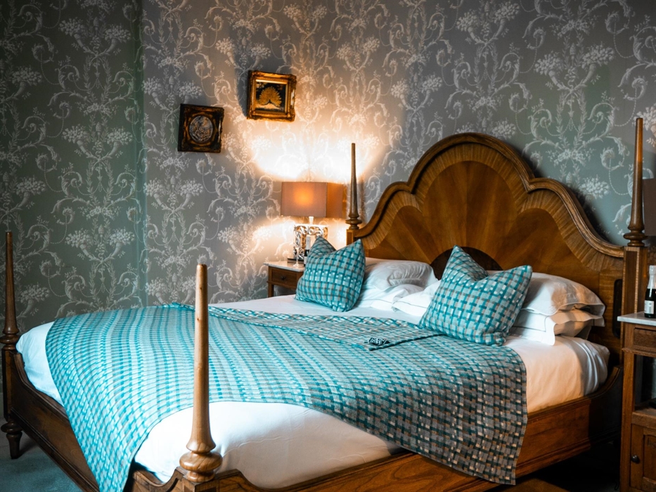 A large, luxurious room with a triple aspect overlooking beautiful open countryside. The centerpiece is a king-size bed. And the indulgence continues