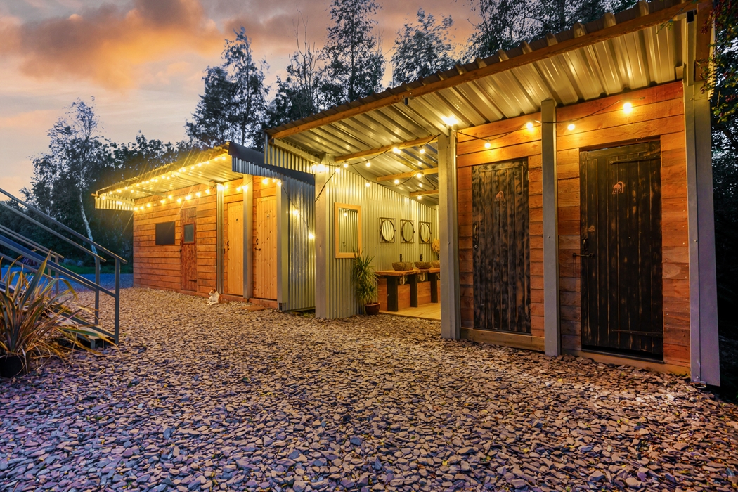 Rustic stylish and eco showers and washing facilities, festoon lights in twilight