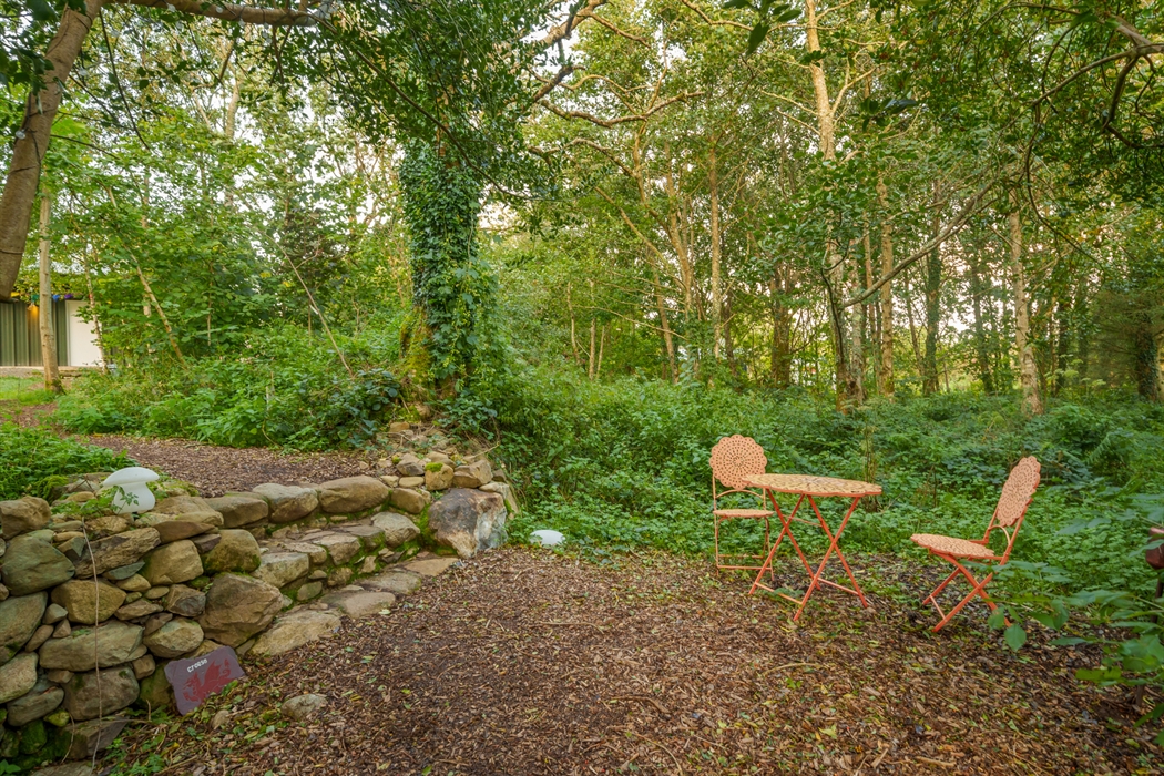 Woodland sitting area with bistro-style chairs and table