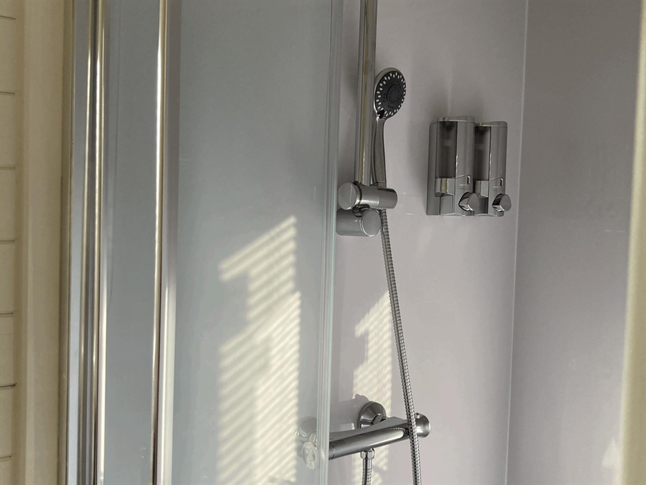 shower unit with shower gel and soap dispensers on wall