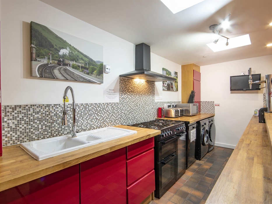 Welsh Row House. Range cooker with extractor. Kitchen Sink. Dishwasher. Washing Machine. Dryer.  Two Four slice toasters and microwave.  Red kitchen c