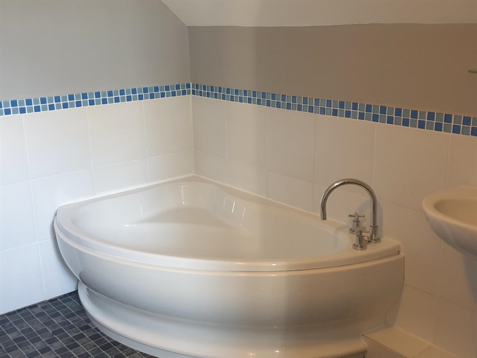 Self catering apartment located on Redford Caravan Park, the bathroom consists of a large corner bath, sink, toilet and enclosed shower.