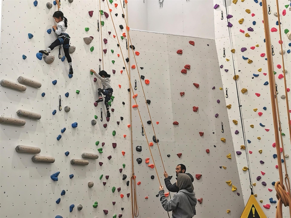 Mum and dad hold the ropes for their two little girls in a quiet area of easy climbs.
