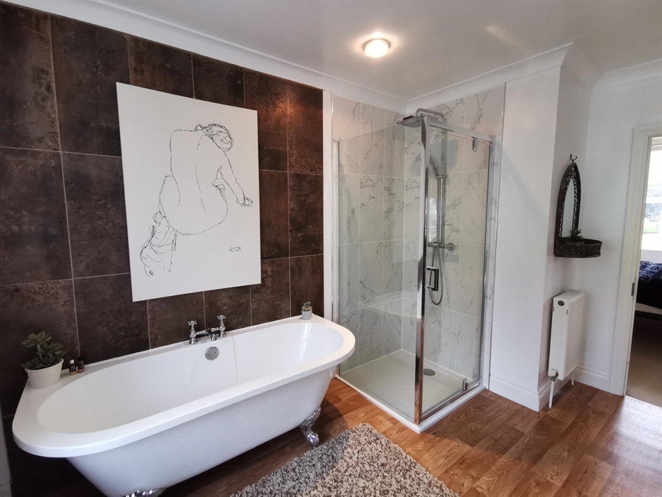 Large ensuite bathroom with a pretty freestanding bath and separate shower cubicle