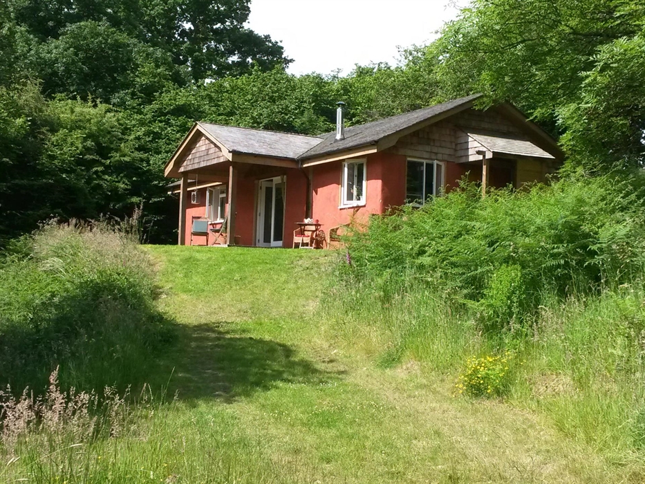 Outside of the cottage with veranda with table and chairs, BBQ and panoramic views