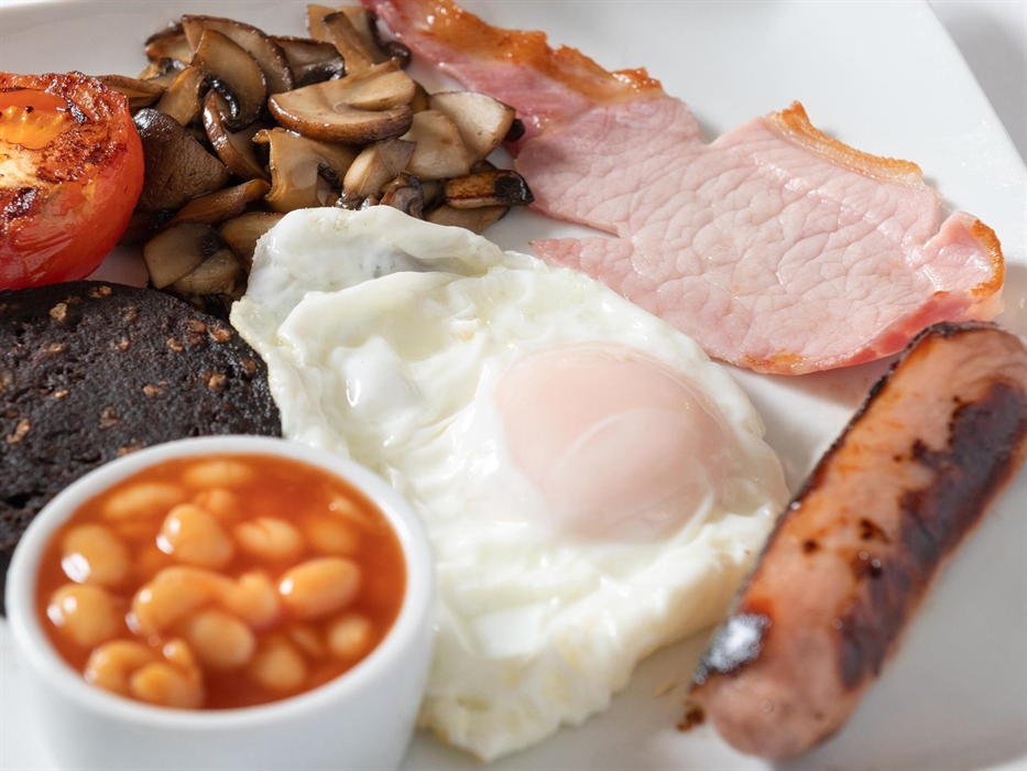 A hearty homemade full Welsh breakfast, featuring locally sourced ingredients. Savoury Welsh back bacon, succulent sausages, egg​ cooked to perfection