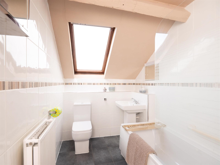 Bathroom with bath and shower in North Wales holiday cottage