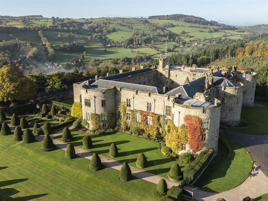 An aerial view of Chirk Castle and garden in autumn with the Virginia Creeper ivy climbing the castle walls and the garden path lined with shaped topi