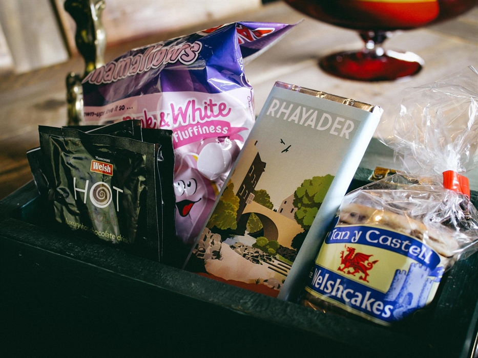 Welcome hamper with marshmallows, welsh cakes, chocolate, hot chocolate, tea, coffee and sugar sachets and milk in the fridge.