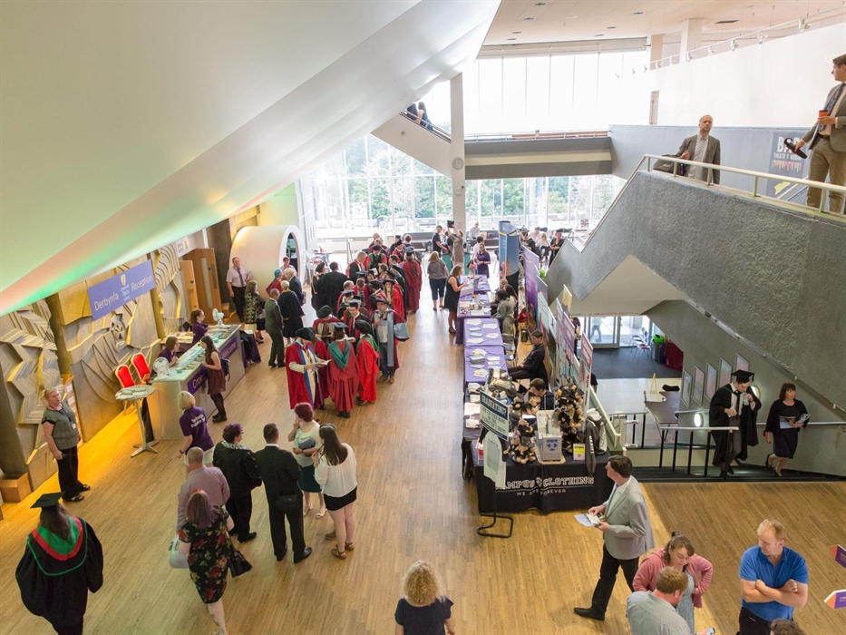 A busy foyer space with large windows and information desks