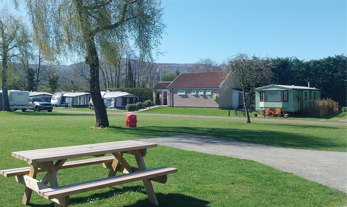Wooden picnic bench adjacent to hardstanding pitch near ladies toilets at Pyscodlyn