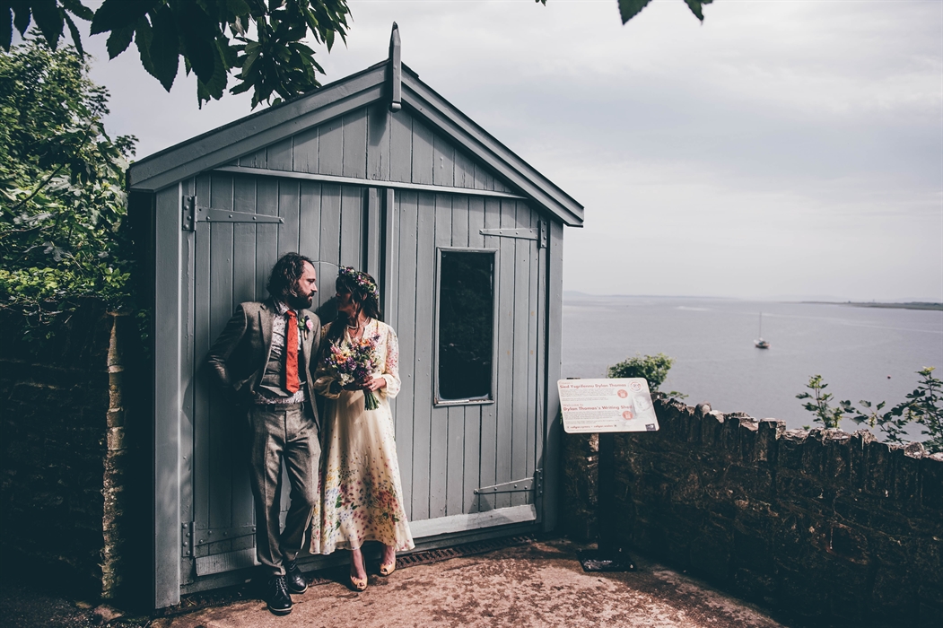 Newly married young couple looking into each other's eyes while leaning against the closed door of the Writing Shed