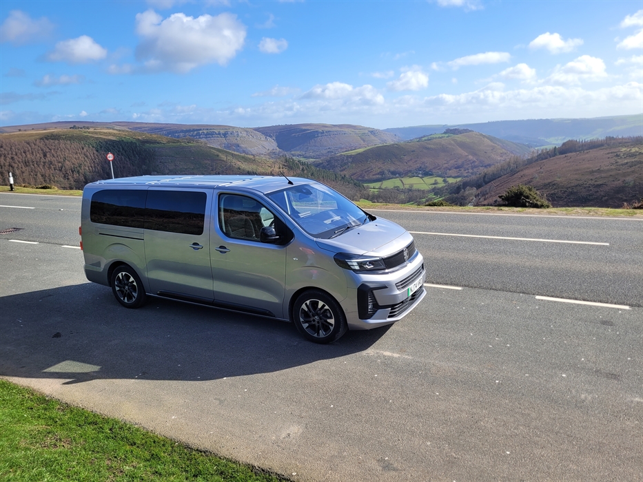 An electric vehicle on a road overlooking mountains