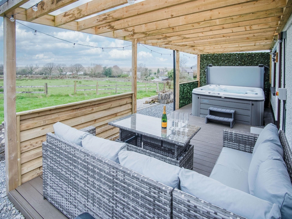 The all weather covered veranda houses our luxury hot tum and comfortable relaxing seating area. There is arrest to the downstairs shower room through