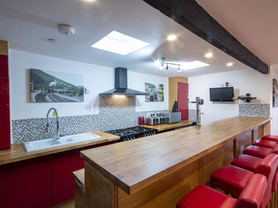 Welsh Row House long breakfast Bar and red leather bar stools. Range cooker with extractor. double sink.  two four slice toasters and microwave.  Anot