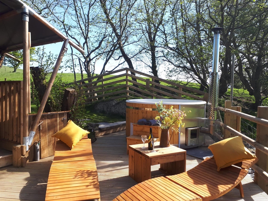 A private wood fired hot tub sits directly outside on the decked veranda.