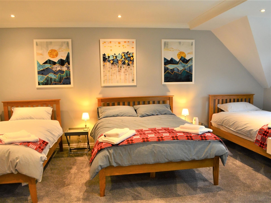 Family room with three beds, two single and one double. En suite