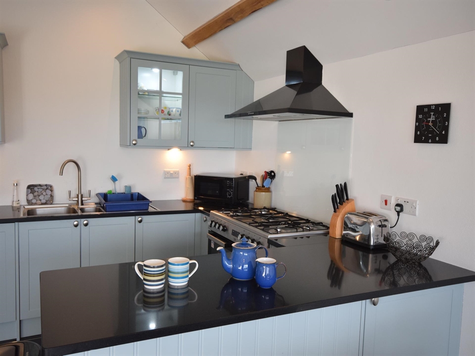 Slate flooring with underfloor heating.
Double electric oven, grill & gas hob. Microwave, kettle, toaster, American style fridge-freezer.