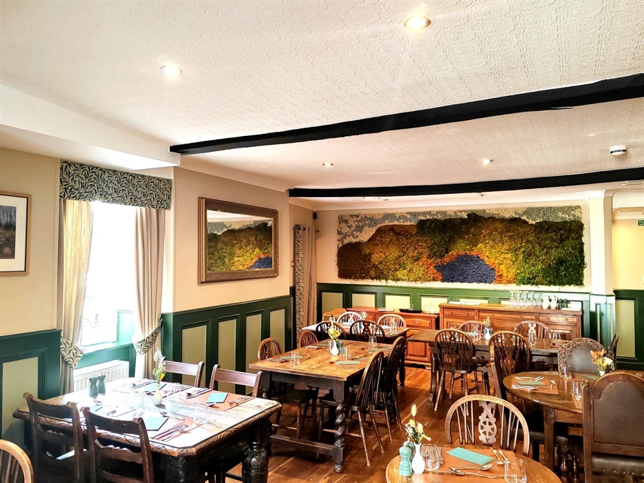 Our rustic dining room with fresh local flowers and our magnificent moss art piece custom made from local moss depicting the local landscape of Llyn y