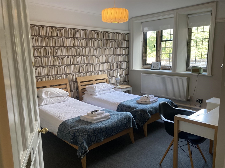 A twin bedroom (two beds with blue blanket)