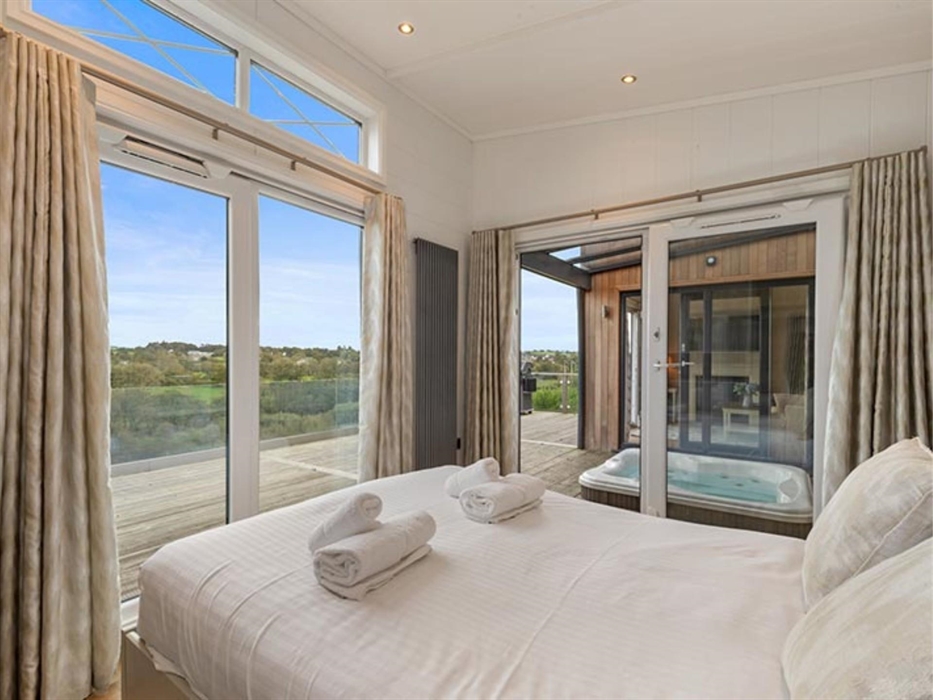 With view of hot tub, deck, living area and countryside.