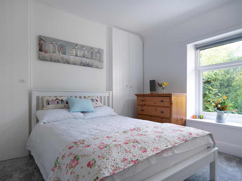 The double bedroom is bright and looks out towards the garden and summerhouse.  There is plenty of storage and a large mirror and ladder shelf unit no