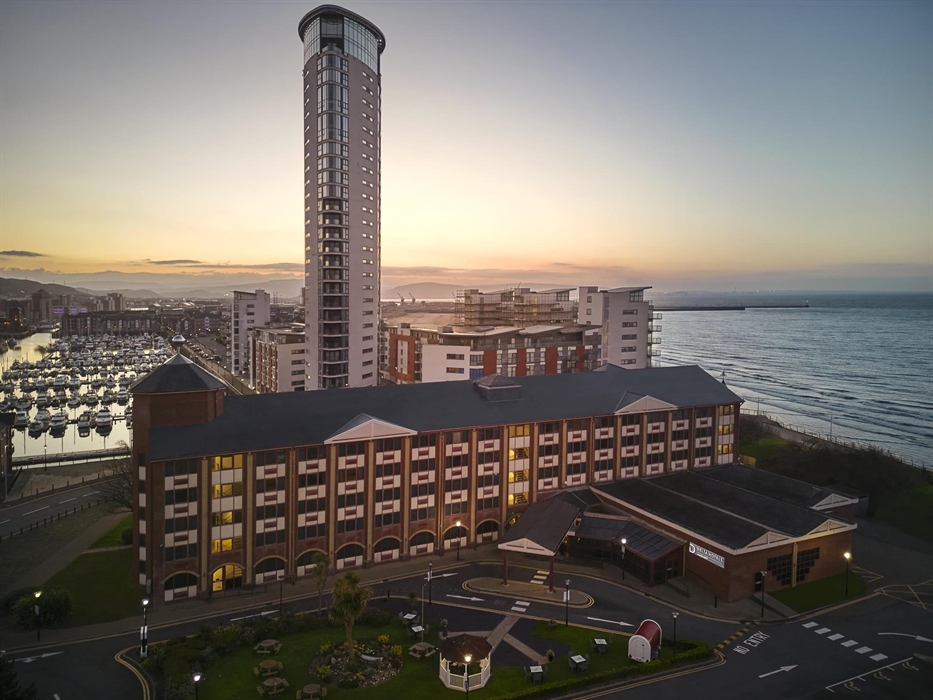 A beautiful view of Delta Hotels by Marriott Swansea with the marina and sea view in the distance. This stunning picture was taken at dawn.
