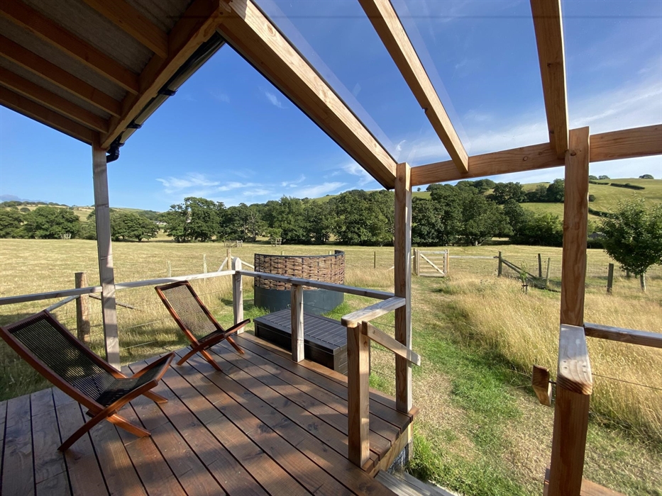 Unique cabin with outdoor deck and verandah overlooking meadow, perfect for relaxation or yoga.