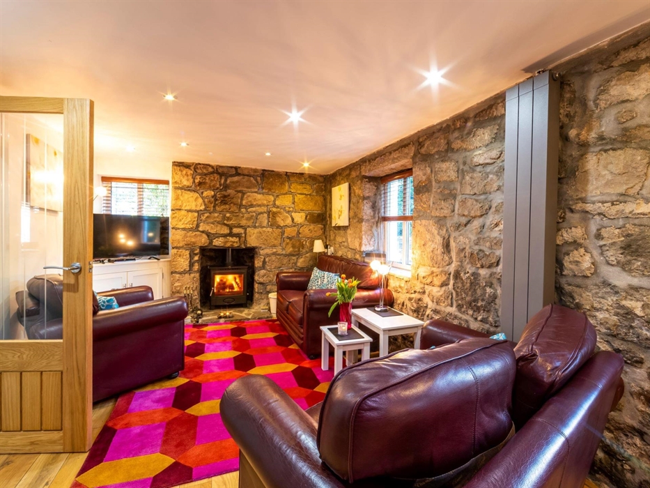 Has comfortable leather seating, an oak floor and rug, a  large screen TV and an irriststible woodburner!
