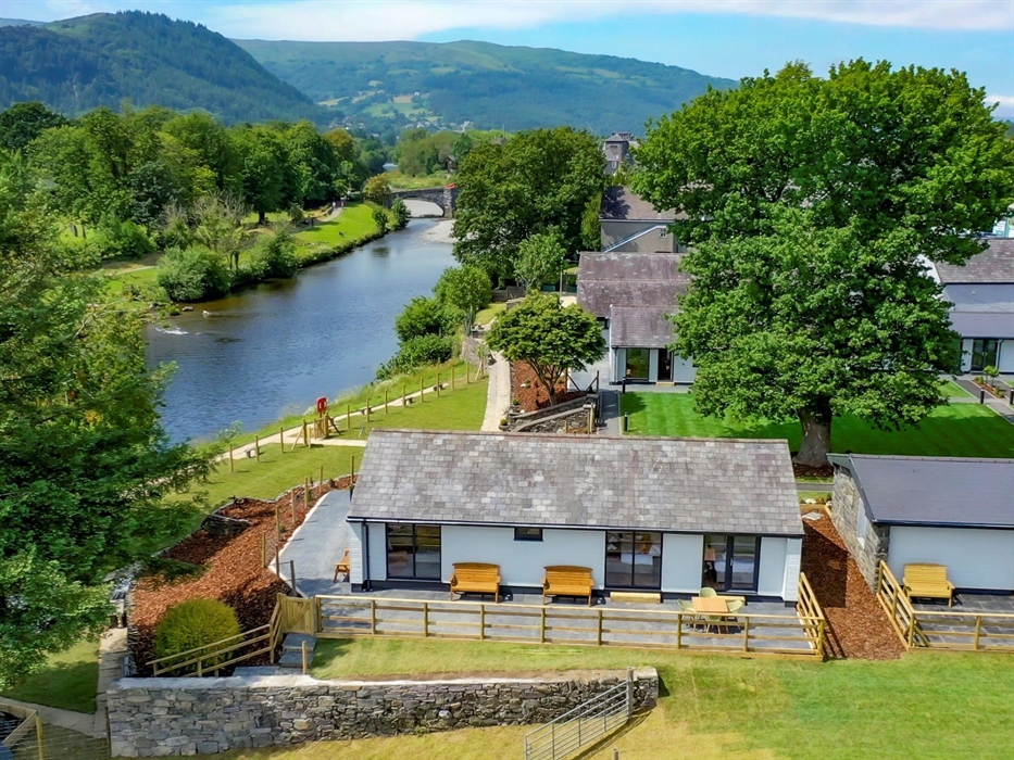 Holiday lodge with river and mountains in background