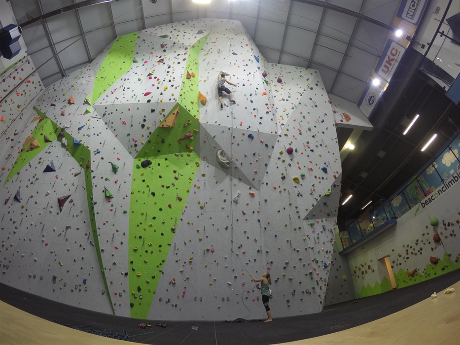 Wide angle view of the biggest climbing walls in the centre, showing it in context with two climbers and low level climbing on one side. The first flo