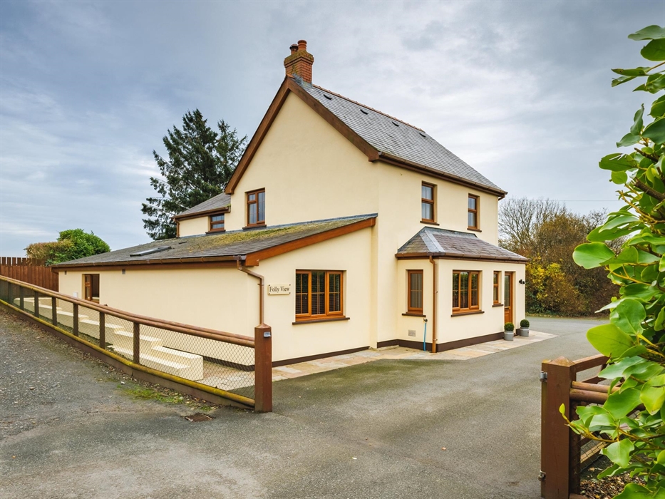 Large cream house with wooden windows and plenty of parking.