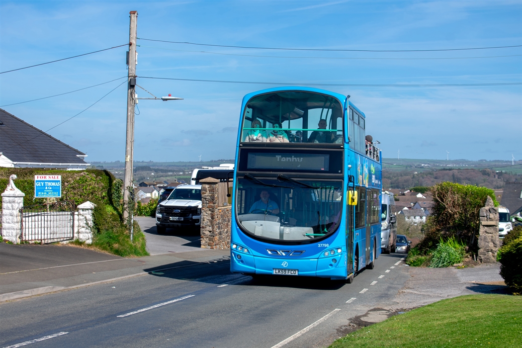 an open-top bus driving along a road