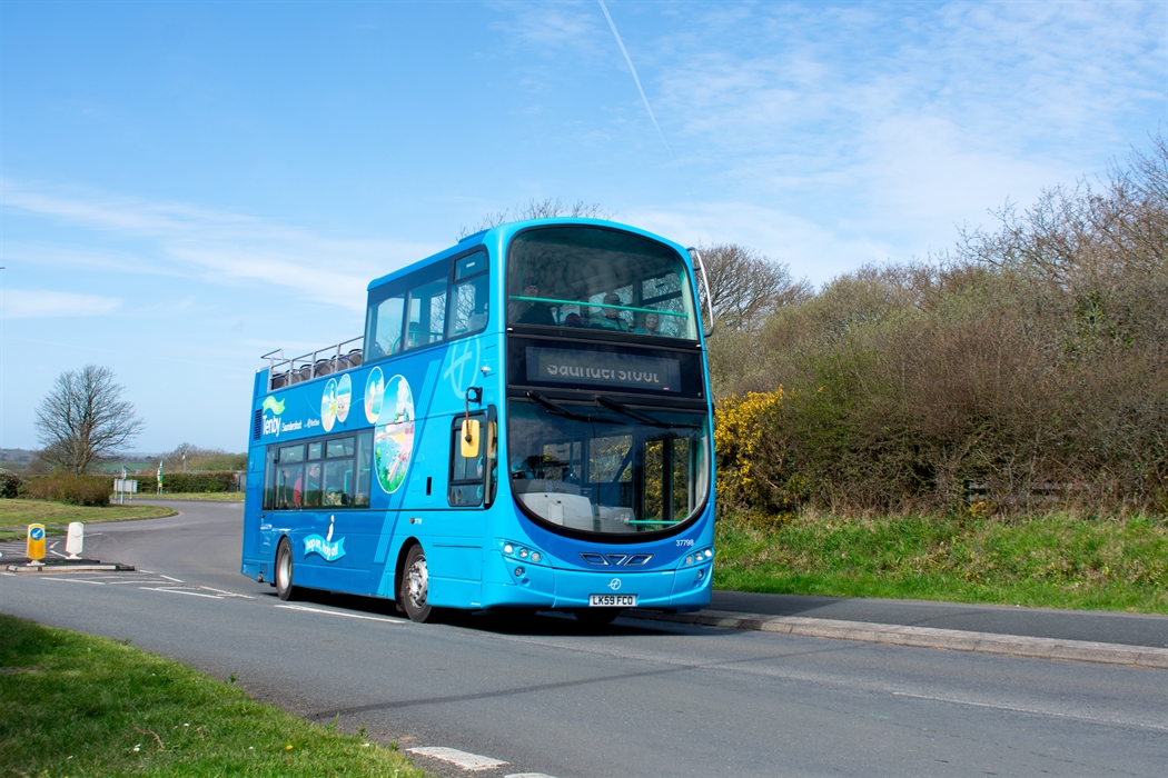 an open-top bus driving along a road