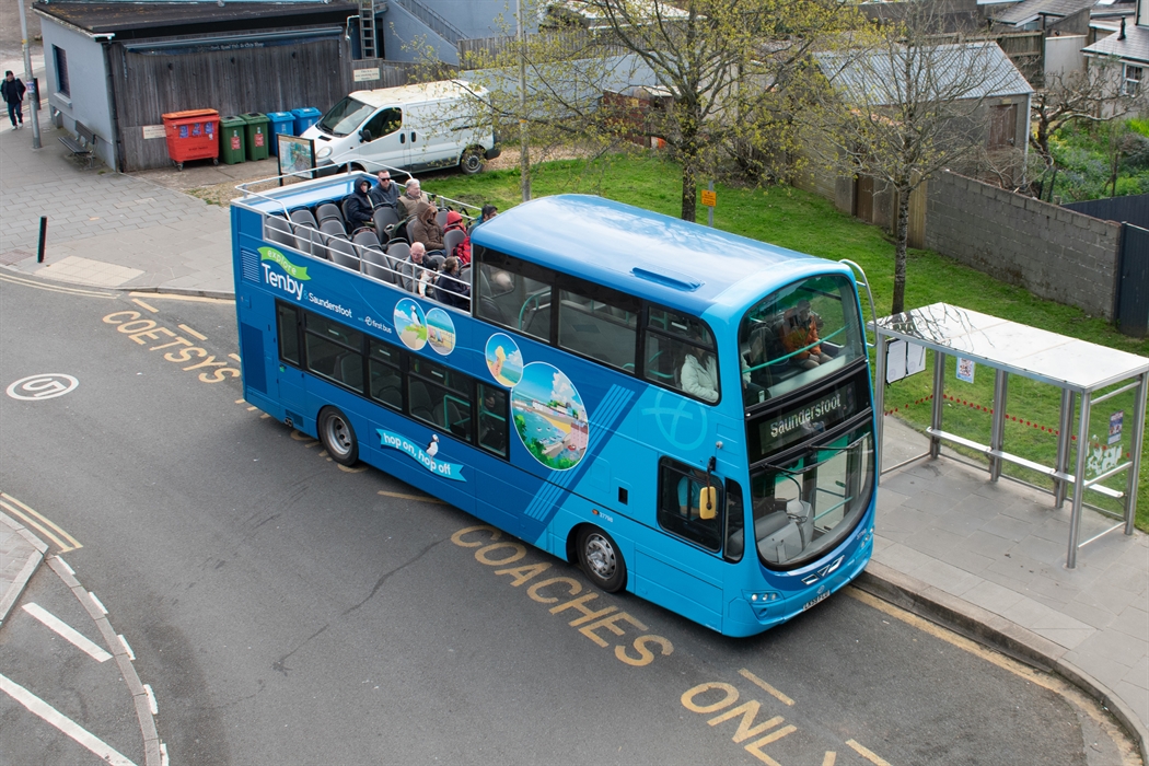 an open-top bus parked in a bus stop
