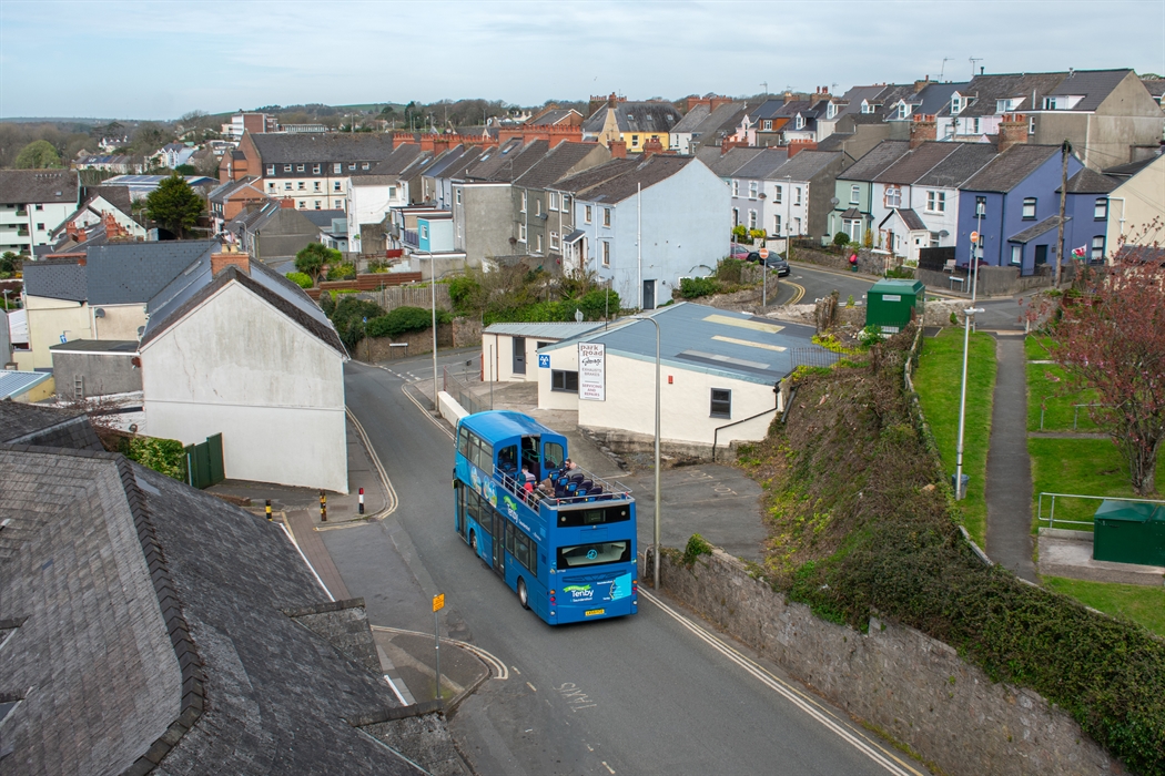 an open-top bus driving down the road