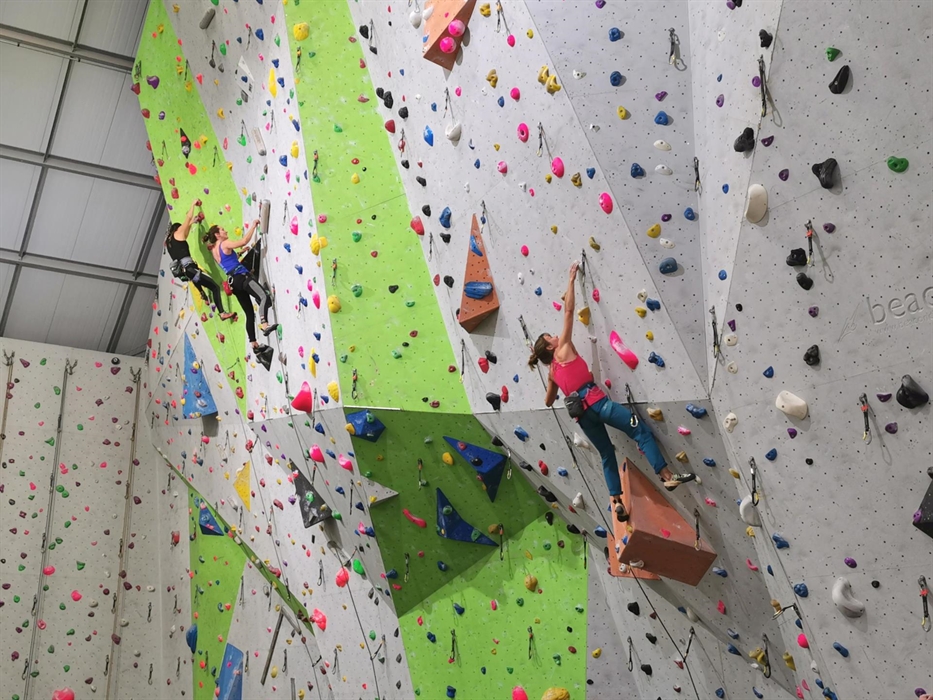 Three experienced climbers lead climb high up on the walls.