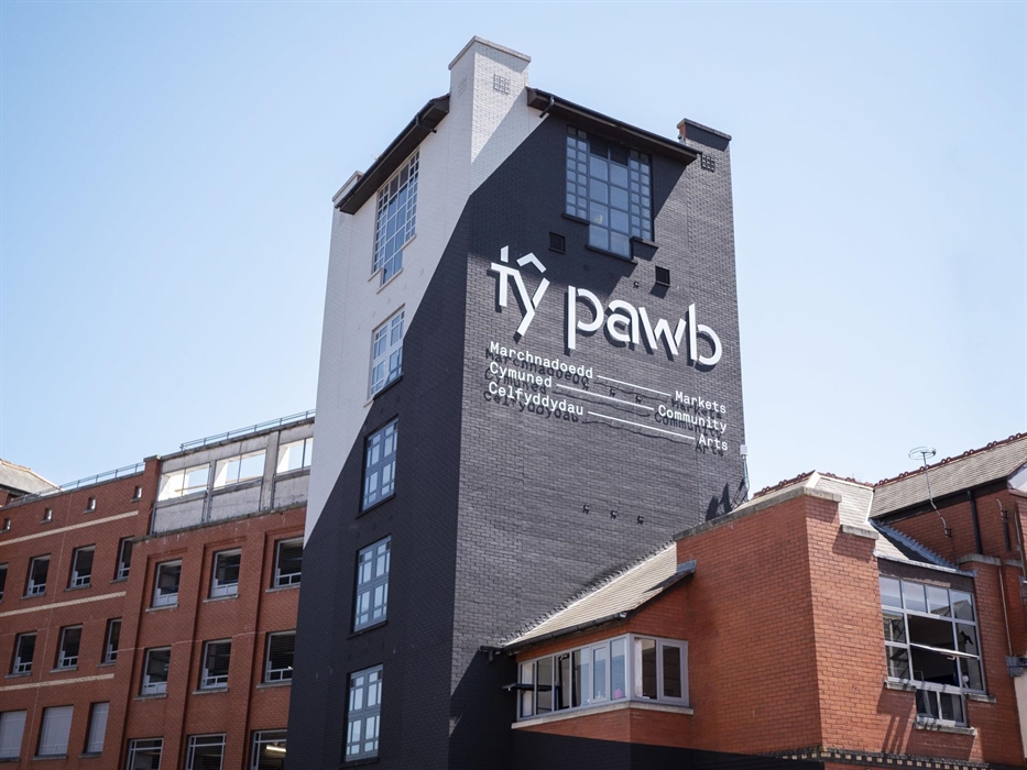 External view of the Tŷ Pawb building, featuring the main tower the Tŷ Pawb logo.