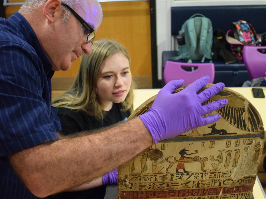 Curator and Student Volunteer studying Graeco-Roman era wooden funerary stela of Pashrinyemhotep.