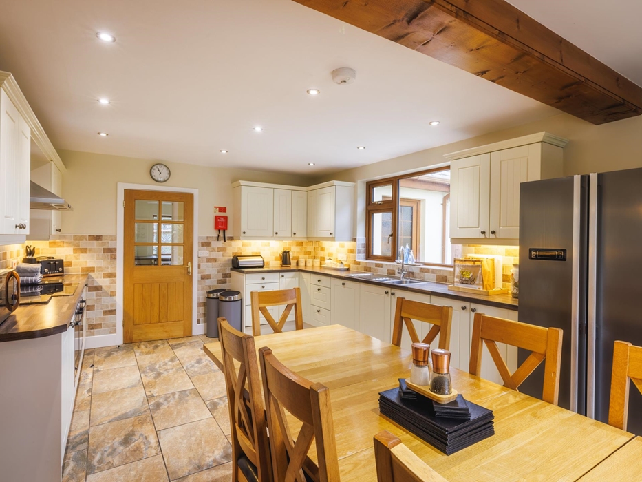 Farmhouse kitchen with shaker-style cupboards and large dining area.