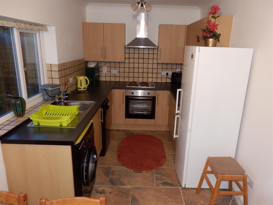 hawthorn kitchen/dining area. Shows full size fridge freezer, oven, hob, washing machine and dishwasher. Table and chairs are situation at the bottom