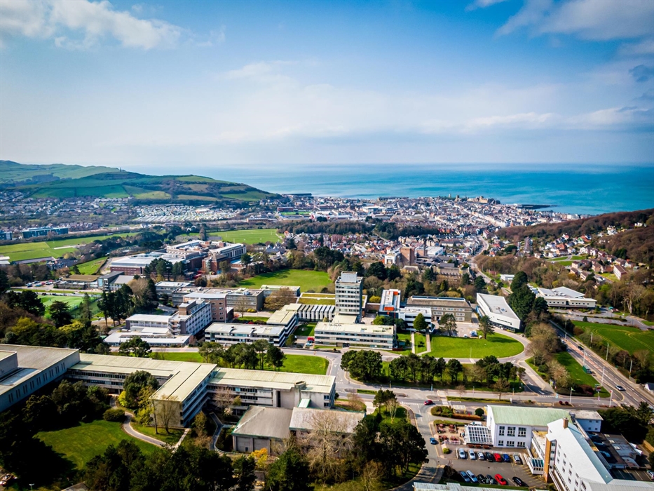 An aeriel view of Aberystwyth University, looking out towards Aberystwyth town and the sea beyond on a bright sunny day